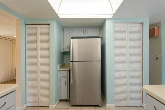 a white refrigerator freezer and a wooden floor