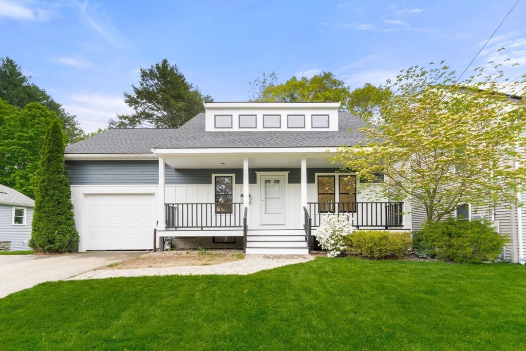 a front view of a house with a garden and yard