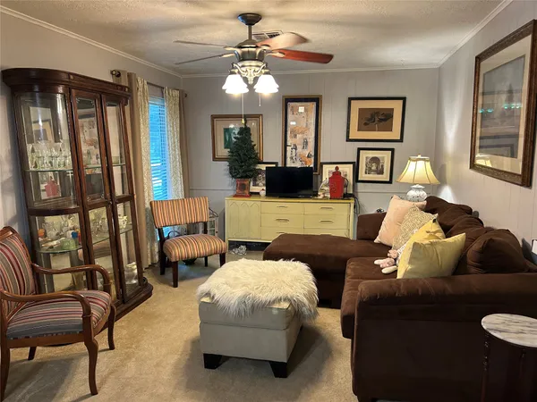 a living room with furniture ceiling fan and a window