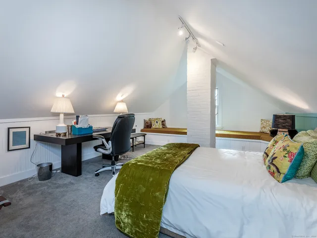 a bed room with a bed and a chair