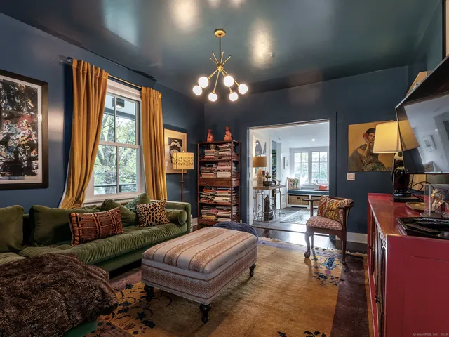 a living room with furniture a large window and a flat screen tv