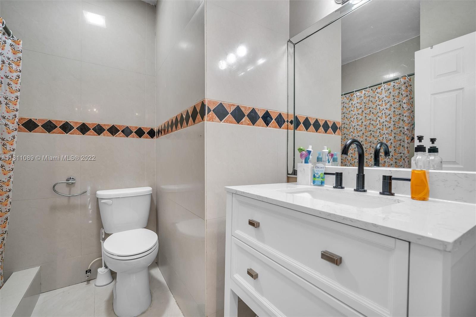 Allapattah Miami, FL 33125 - Photo 21 of 37 a bathroom with a sink a toilet and a mirror