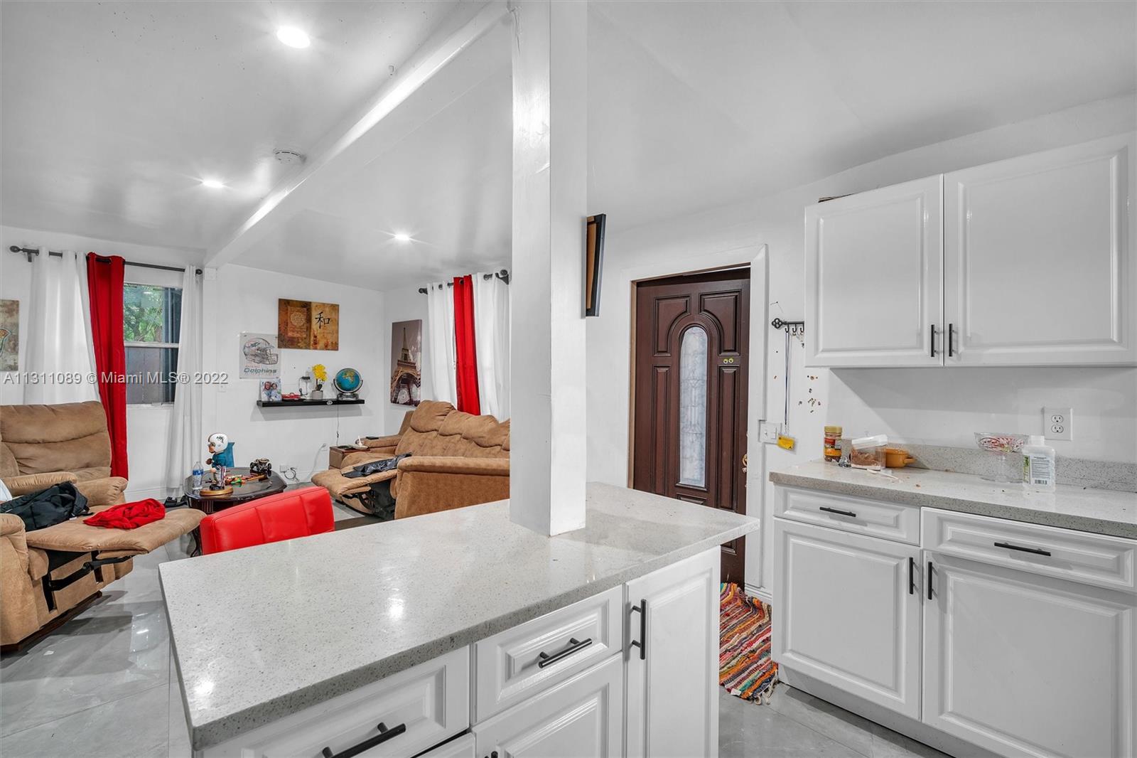 Allapattah Miami, FL 33125 - Photo 31 of 37 a living room with stainless steel appliances furniture a flat screen tv and kitchen view