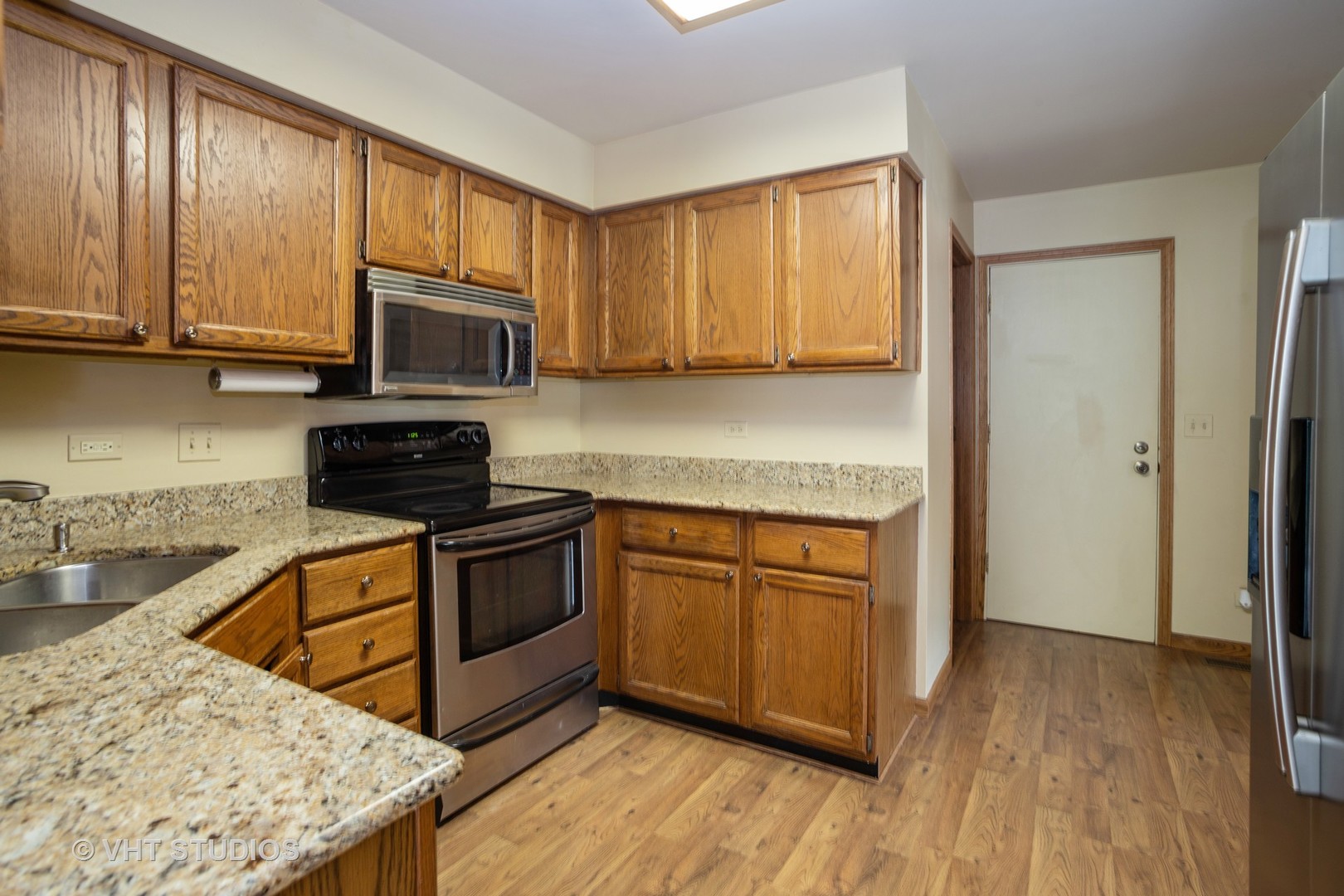 67 Bright Ridge Drive Schaumburg, IL 60194 - Photo 6 of 16 a kitchen with stainless steel appliances granite countertop wooden cabinets a stove top oven a sink and dishwasher with wooden floor
