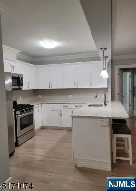 a kitchen with stainless steel appliances a stove a sink and a microwave