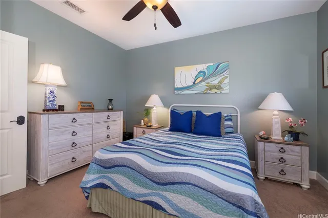 a bedroom with a bed and a lamp on dresser