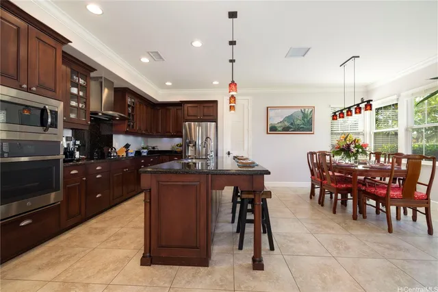 a kitchen with stainless steel appliances granite countertop a table and chairs in it