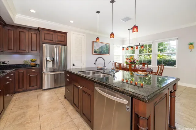 a kitchen with stainless steel appliances granite countertop a sink and a refrigerator