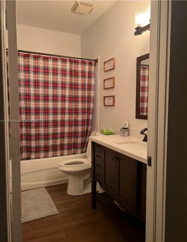 a bathroom with a sink a toilet a mirror and shower