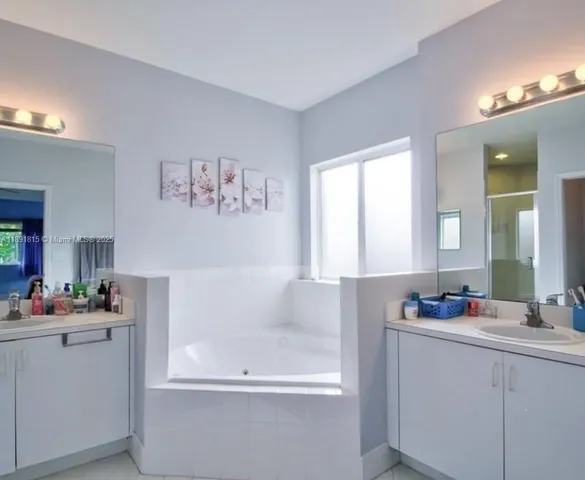 a bathroom with a bathtub sink and mirror