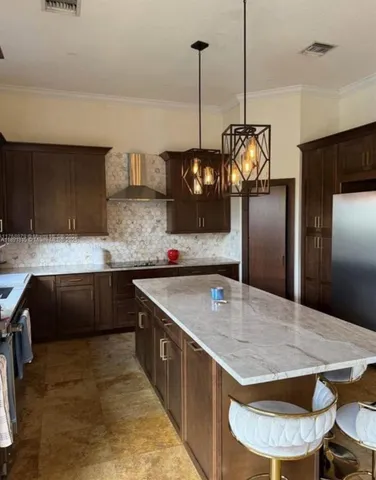 a kitchen with stainless steel appliances granite countertop a sink a stove and a wooden floors