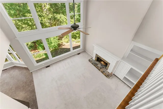 a view of a room with a ceiling fan and window
