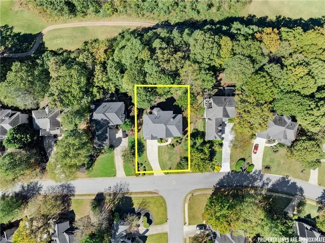 an aerial view of residential houses with outdoor space and trees