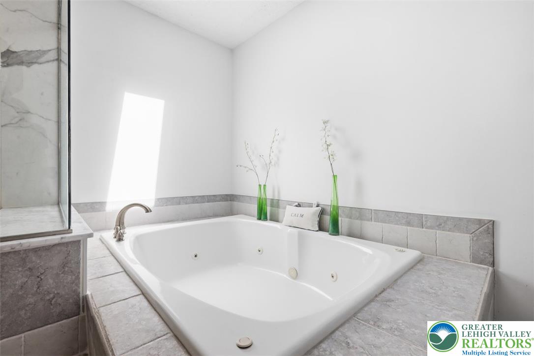 123 Meadow Road Blakeslee, PA 18610 - Photo 18 of 53 A deep soaking tub is framed by tiled surrounds under natural light.