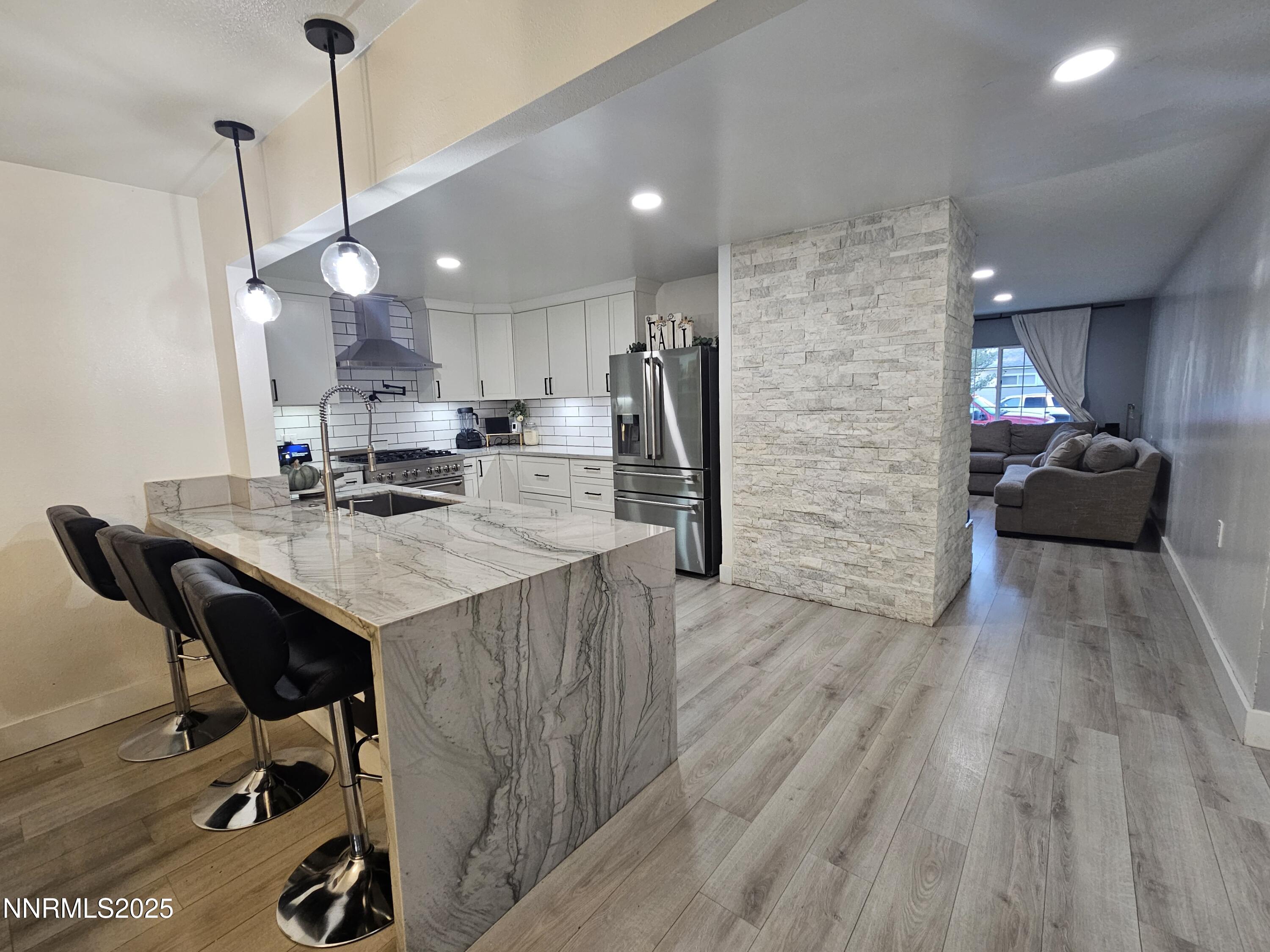181 Quail Street Sparks, NV 89431 - Photo 16 of 42 a kitchen with kitchen island white cabinets and stainless steel appliances