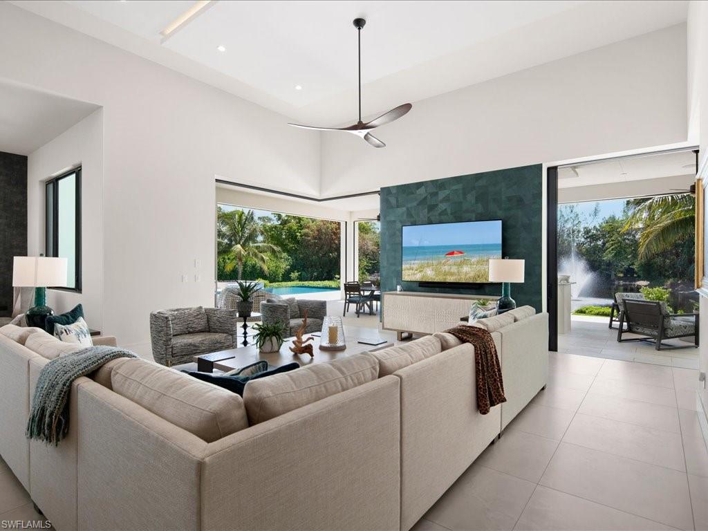 172 Center Street Naples, FL 34108 - Photo 21 of 50 a living room with furniture a large window and a flat screen tv