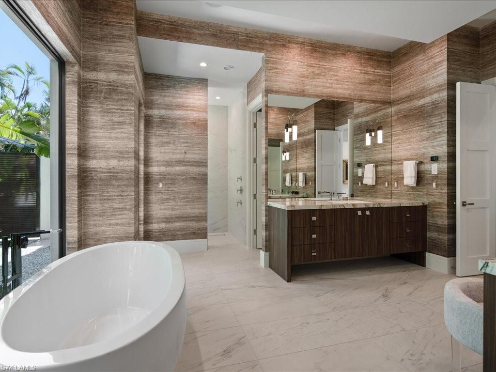 172 Center Street Naples, FL 34108 - Photo 26 of 50 a bathroom with a tub a double vanity sink a mirror a shower and vanity