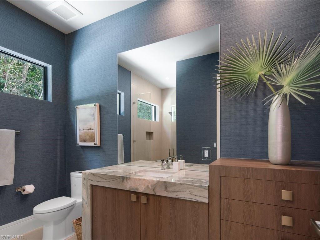 172 Center Street Naples, FL 34108 - Photo 29 of 50 a bathroom with a granite countertop sink a toilet and mirror