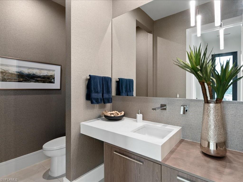 172 Center Street Naples, FL 34108 - Photo 35 of 50 a bathroom with a sink a toilet and a mirror