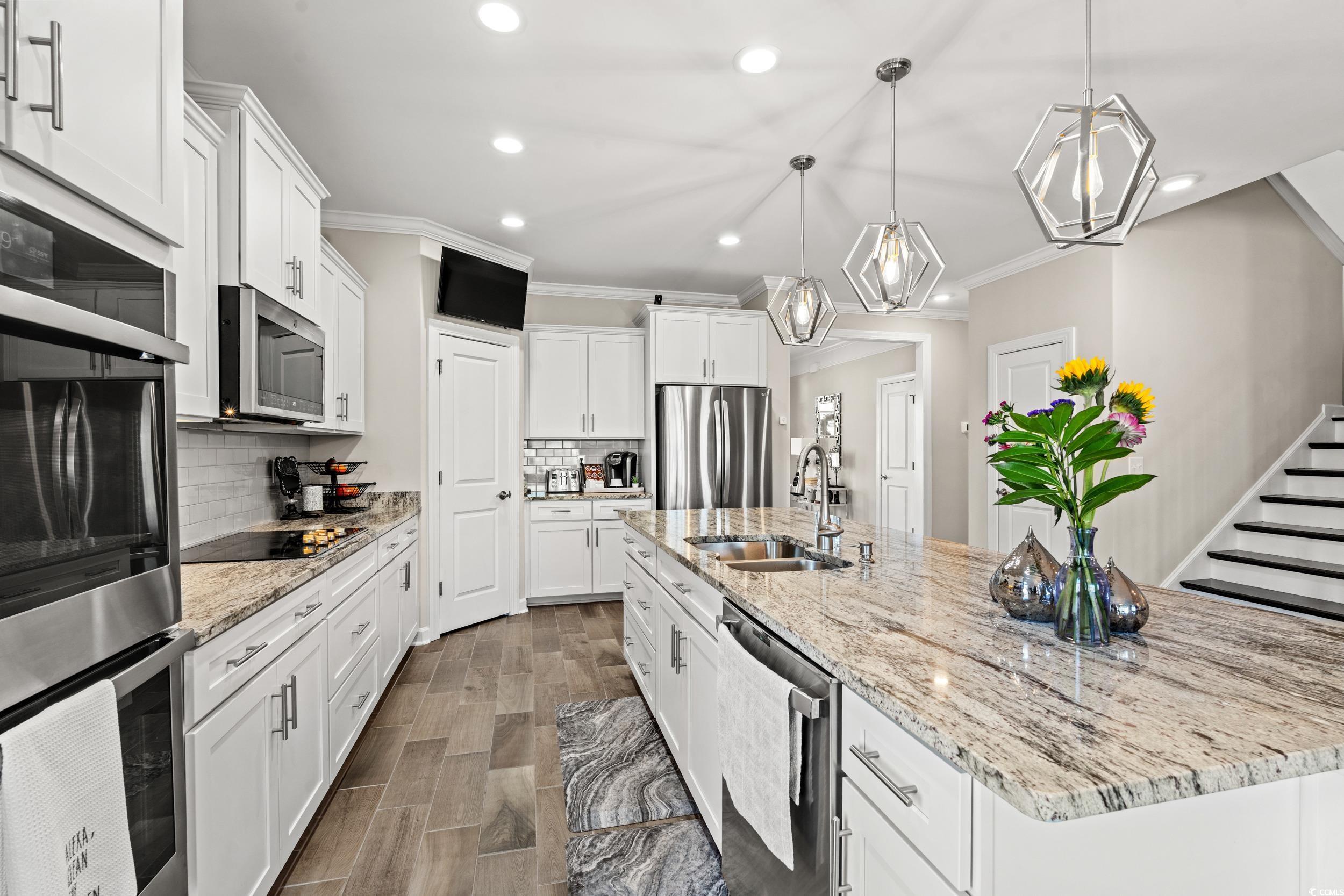 457 Cascade Loop Little River, SC 29566 - Photo 6 of 40 Kitchen featuring white cabinets, backsplash, stai