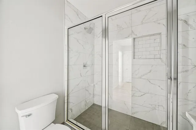 a bathroom with a shower and toilet