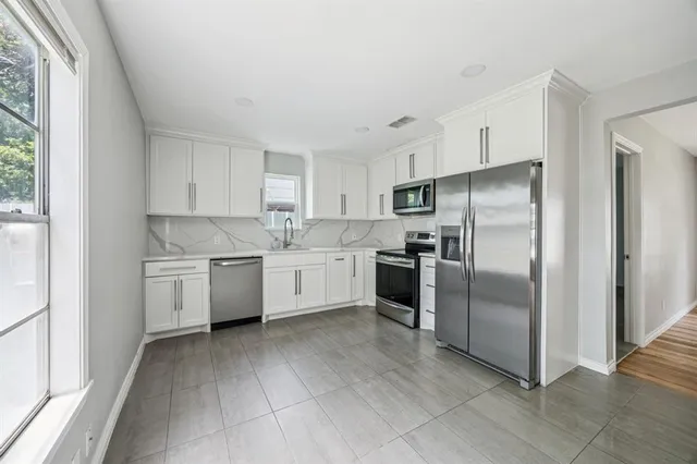 a kitchen with a white cabinets stainless steel appliances and a window