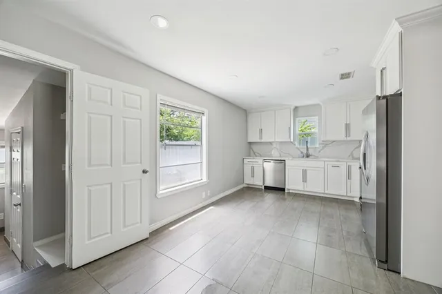 a view of a kitchen with a sink and a refrigerator