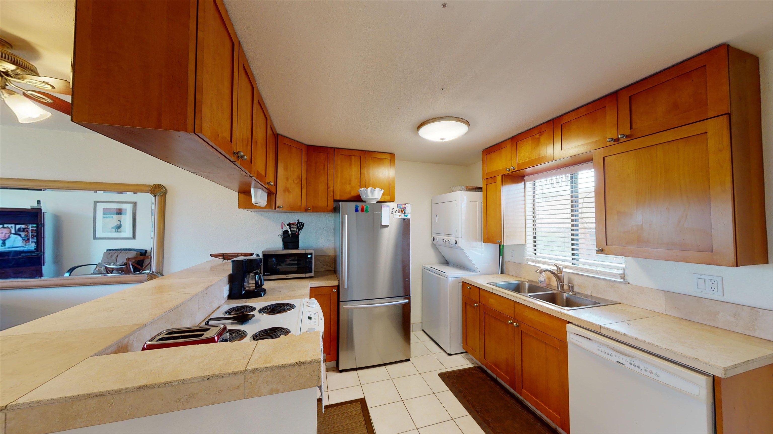 2219 South Kihei Road, Unit A408 Kihei, HI 96753 - Photo 15 of 30 a room with kitchen island stainless steel appliances a sink a counter top space and a window