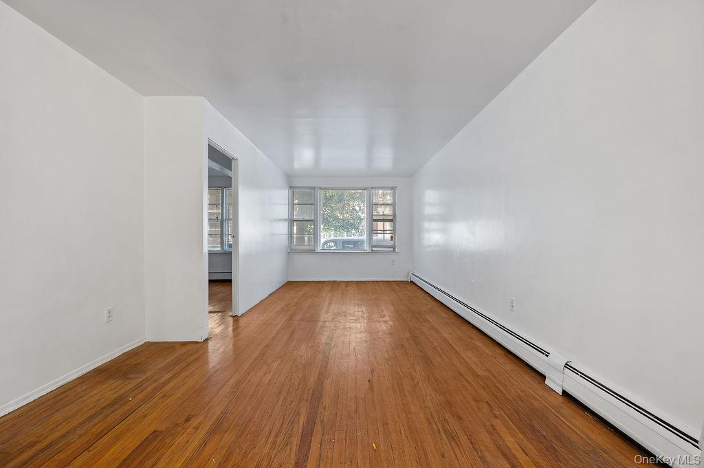 41-30 45th Street Queens, NY 11104 - Photo 3 of 16 an empty room with wooden floor and windows
