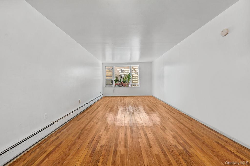 41-30 45th Street Queens, NY 11104 - Photo 8 of 16 an empty room with wooden floor and windows