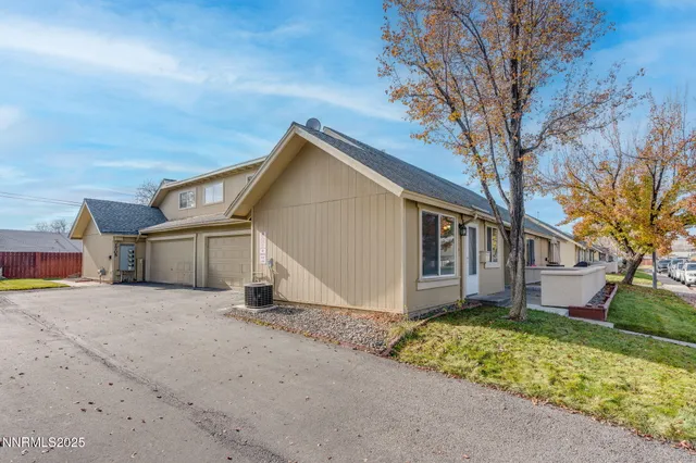 a view of a house with a large tree next to a yard