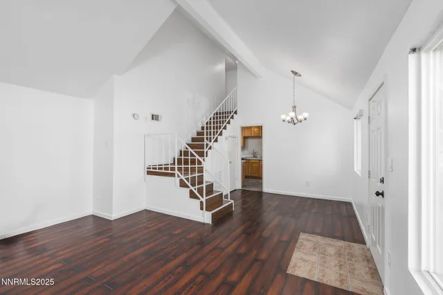 an empty room with wooden floor and staircase