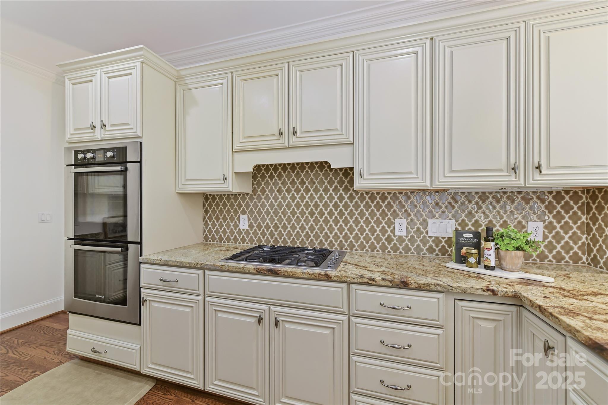 18512 Square Sail Road Cornelius, NC 28031 - Photo 15 of 40 a kitchen with granite countertop white cabinets and stainless steel appliances