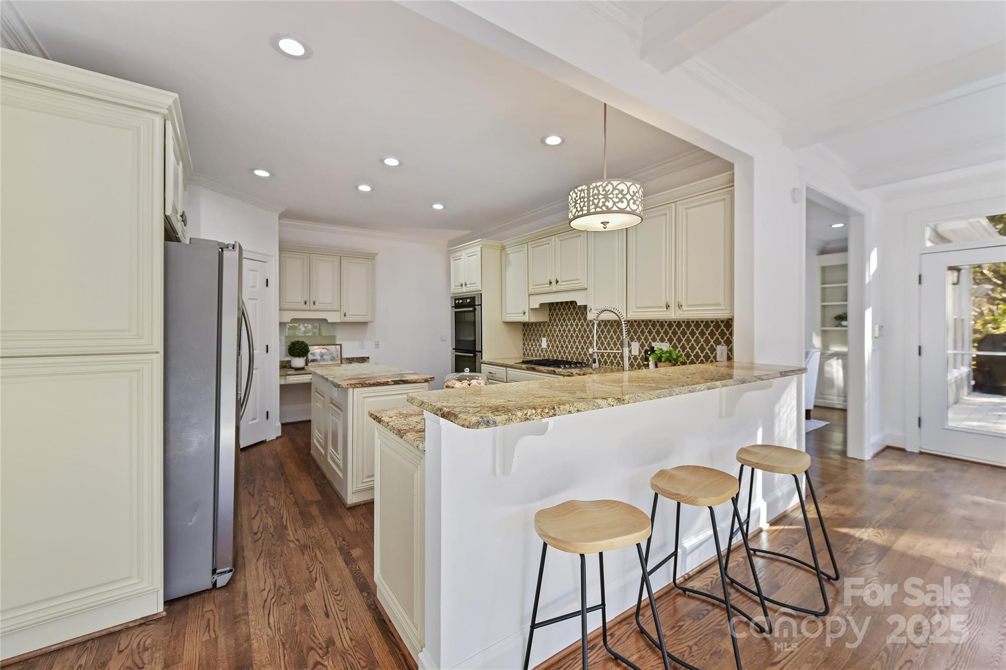 18512 Square Sail Road Cornelius, NC 28031 - Photo 16 of 40 a kitchen with stainless steel appliances granite countertop a refrigerator a stove a sink a dining table and chairs with wooden floor