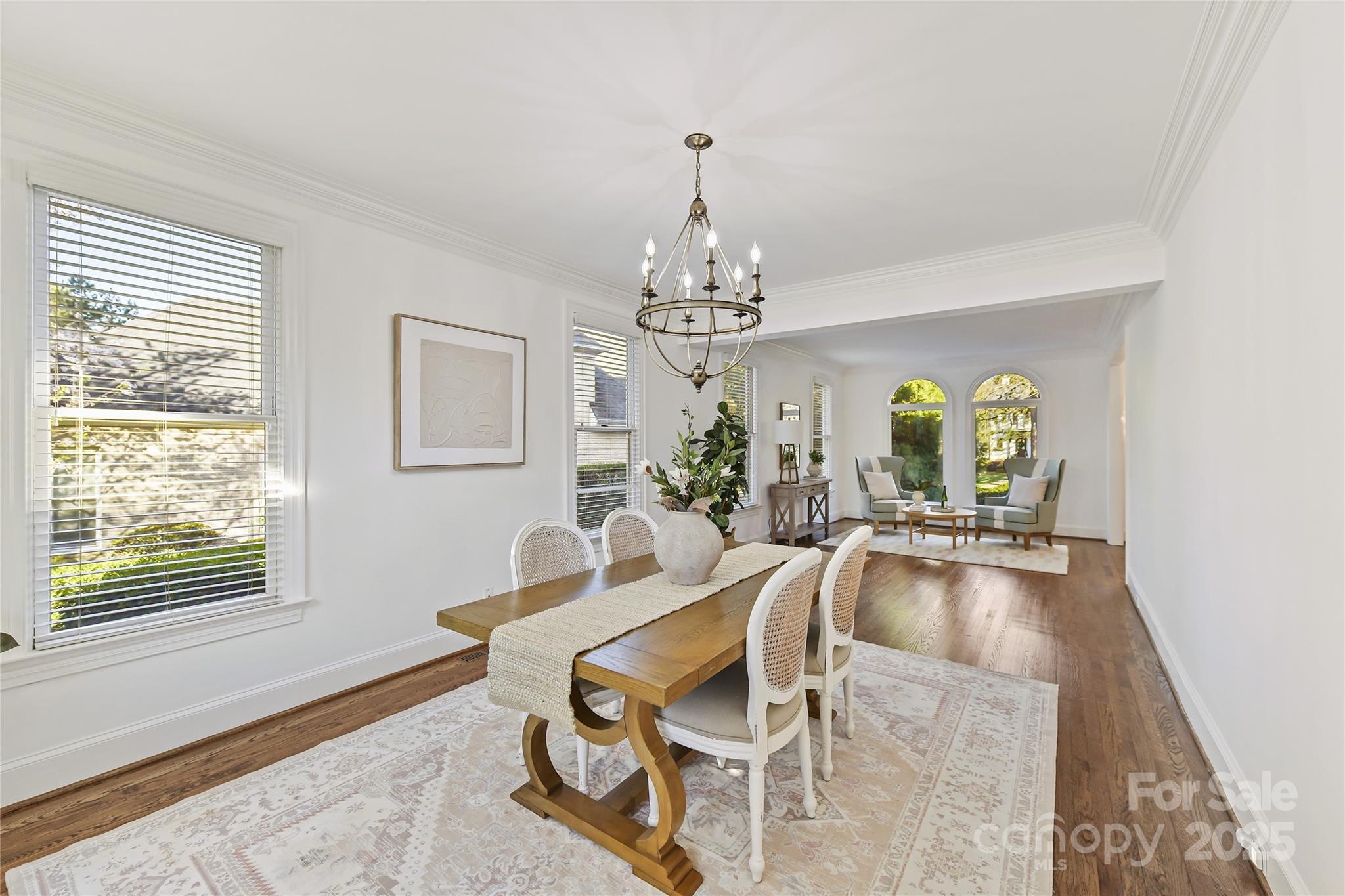 18512 Square Sail Road Cornelius, NC 28031 - Photo 10 of 40 a dining room with wooden floor a chandelier a wooden table and chairs
