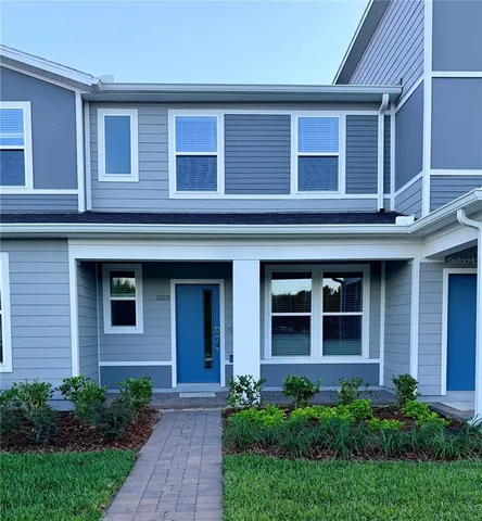 a view of brick house with large windows and a yard