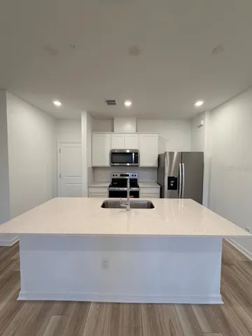 a large kitchen with kitchen island stainless steel appliances sink and stove