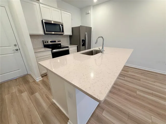 a kitchen with stainless steel appliances a refrigerator sink and stove