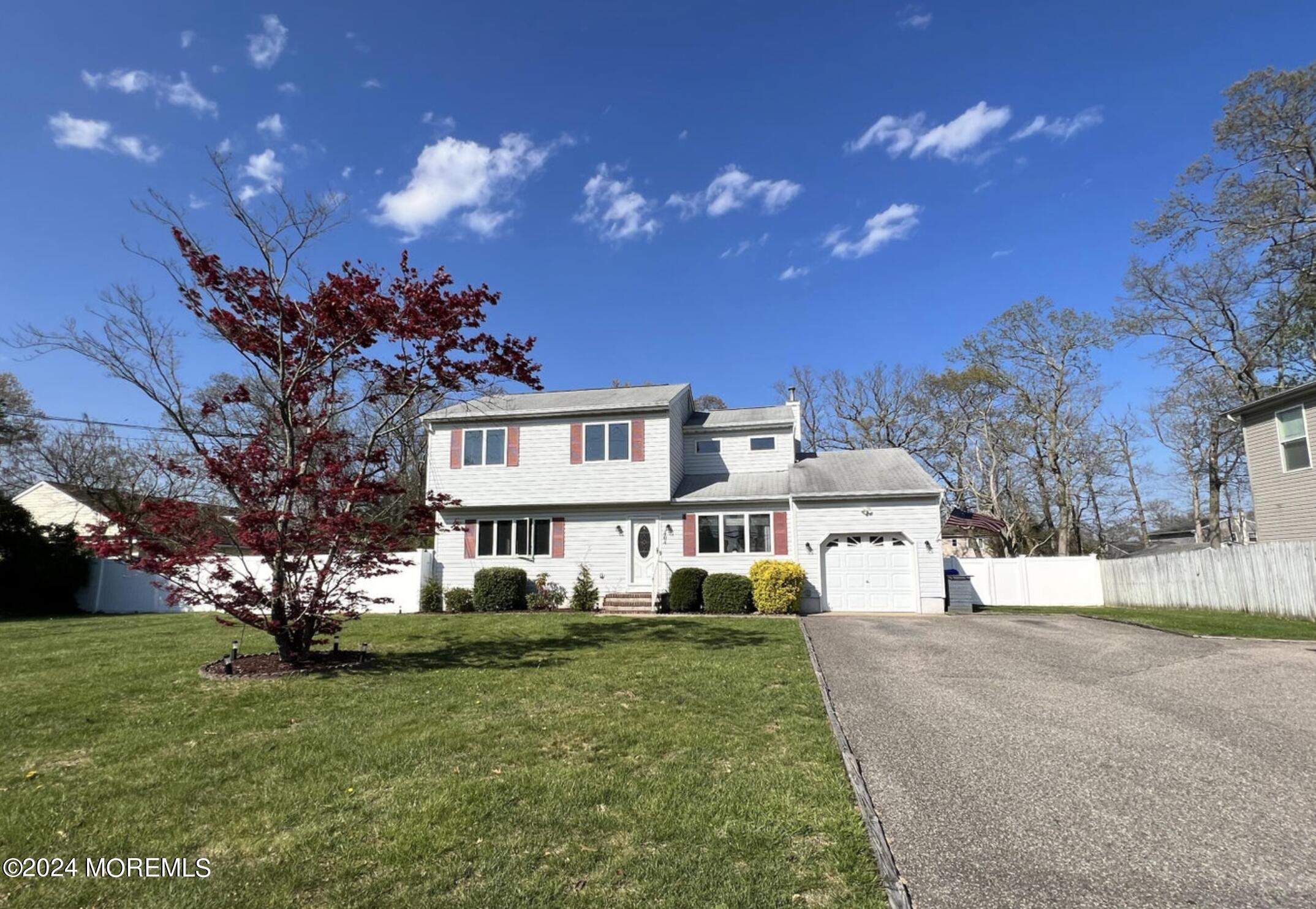 a front view of a house with a yard and garden