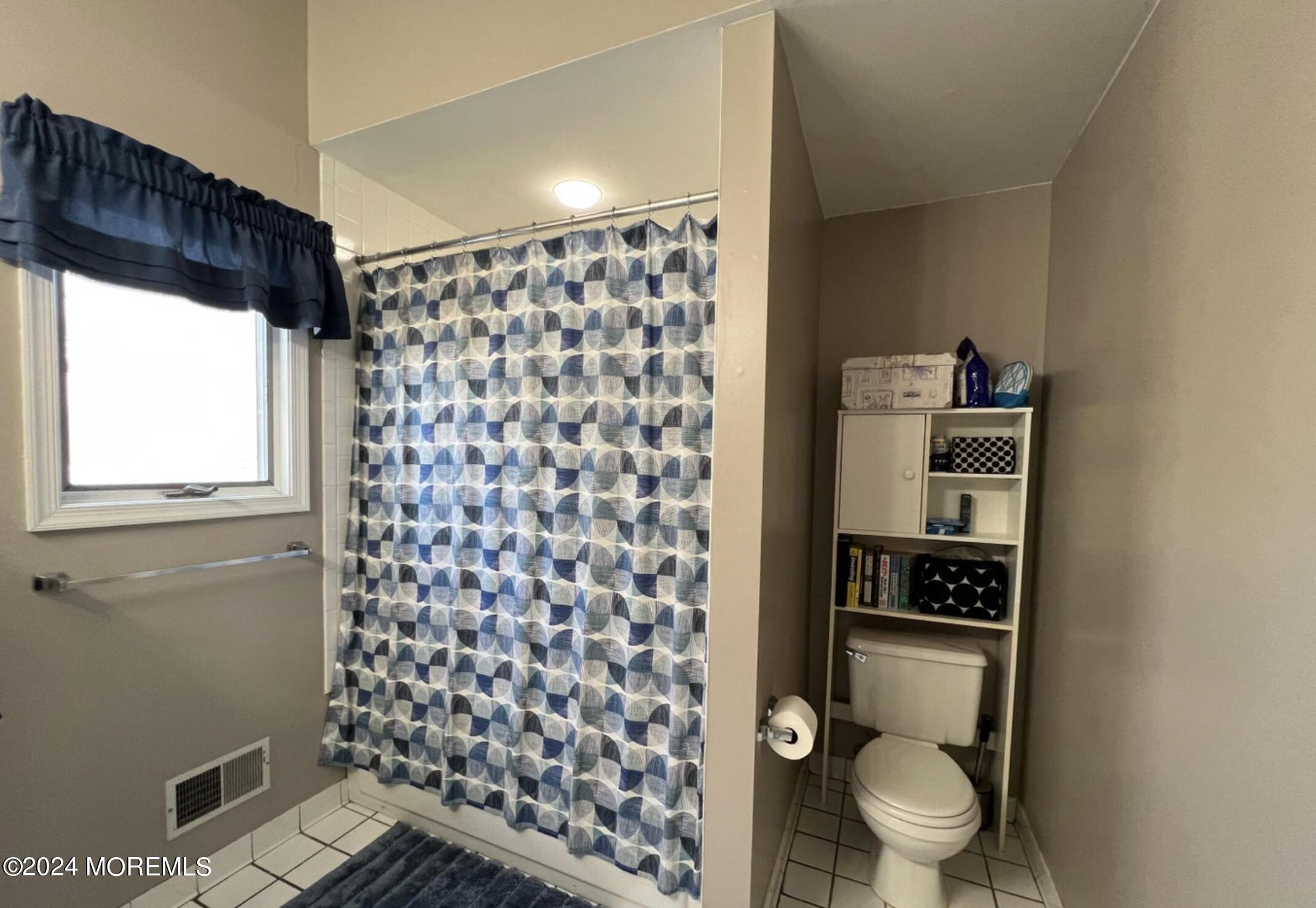 404 Drum Point Road Brick, NJ 08723 - Photo 16 of 22 a bathroom with a toilet and a shower curtain