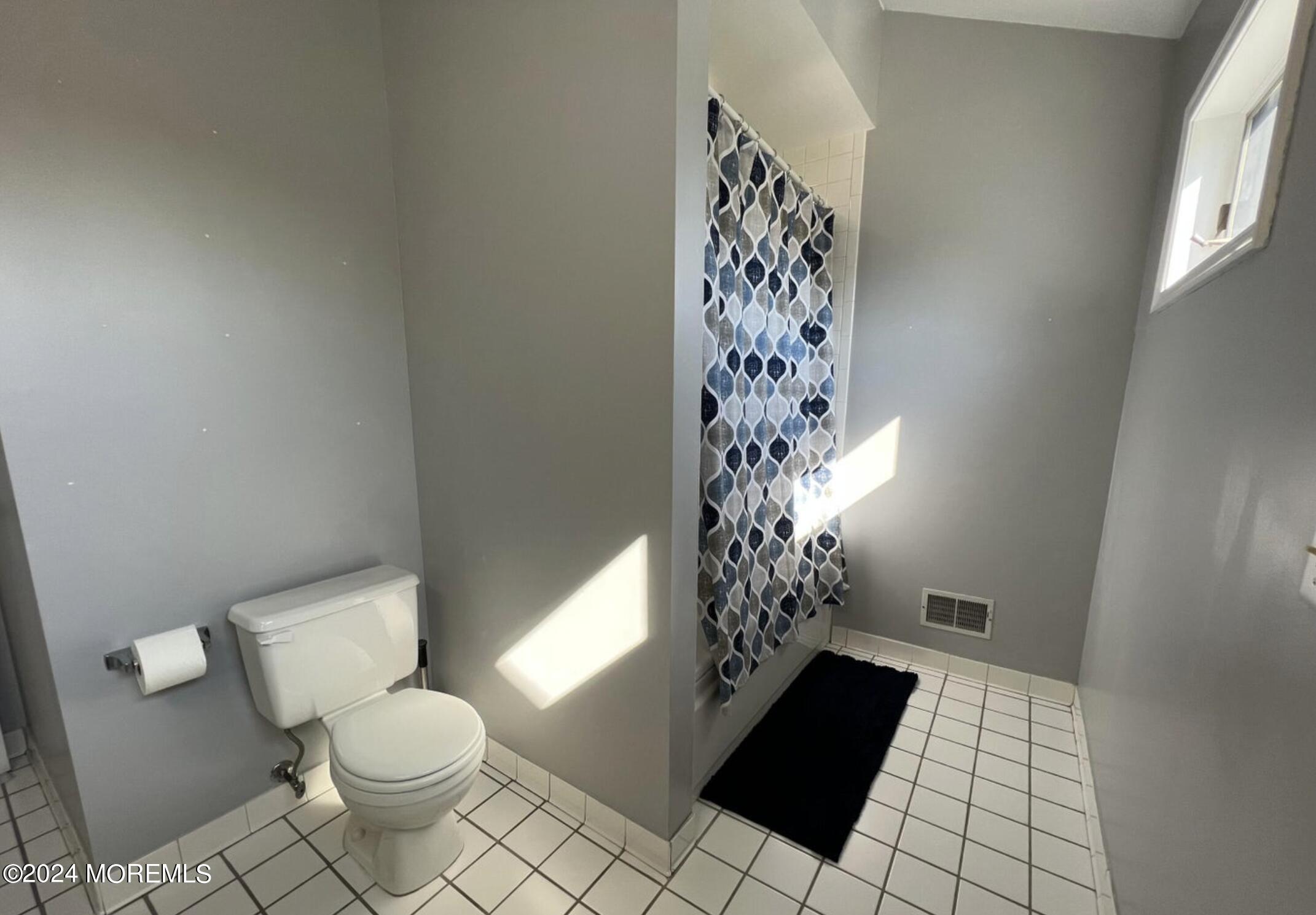 404 Drum Point Road Brick, NJ 08723 - Photo 20 of 22 a bathroom with a toilet and a shower curtain