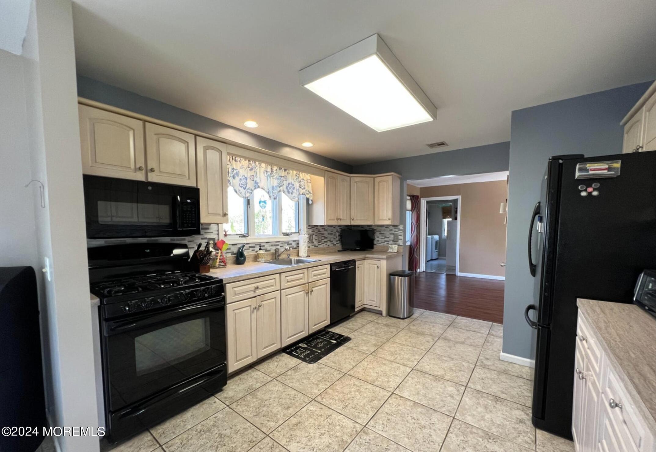404 Drum Point Road Brick, NJ 08723 - Photo 6 of 22 a kitchen with a sink a stove and refrigerator