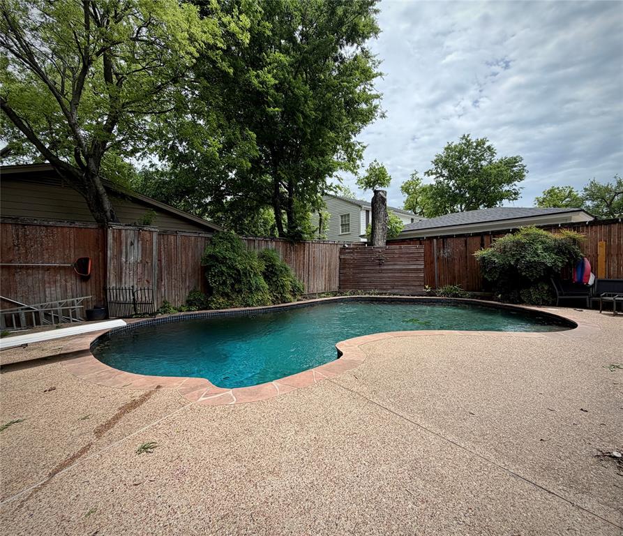 301 Forrest Avenue Cleburne, TX 76033 - Photo 2 of 14 Curved swimming pool with an exposed aggregate concrete deck