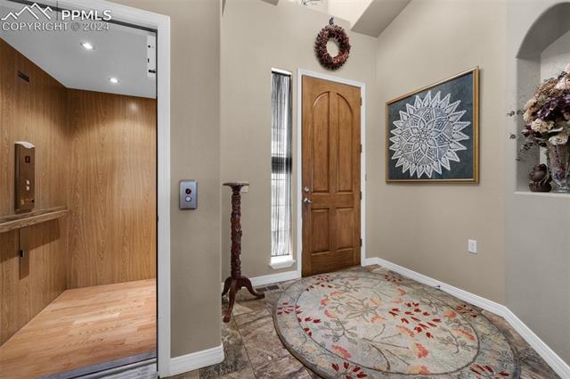 533 Talus Road Monument, CO 80132 - Photo 13 of 46 Foyer featuring elevator, wood walls, and hardwood / wood-style flooring
