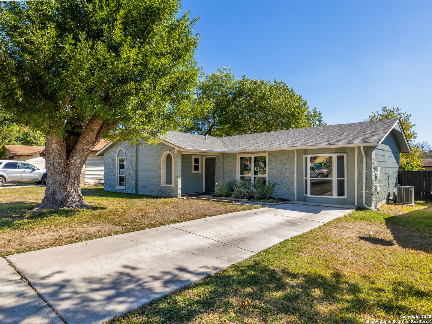 a front view of house with yard and trees in the background
