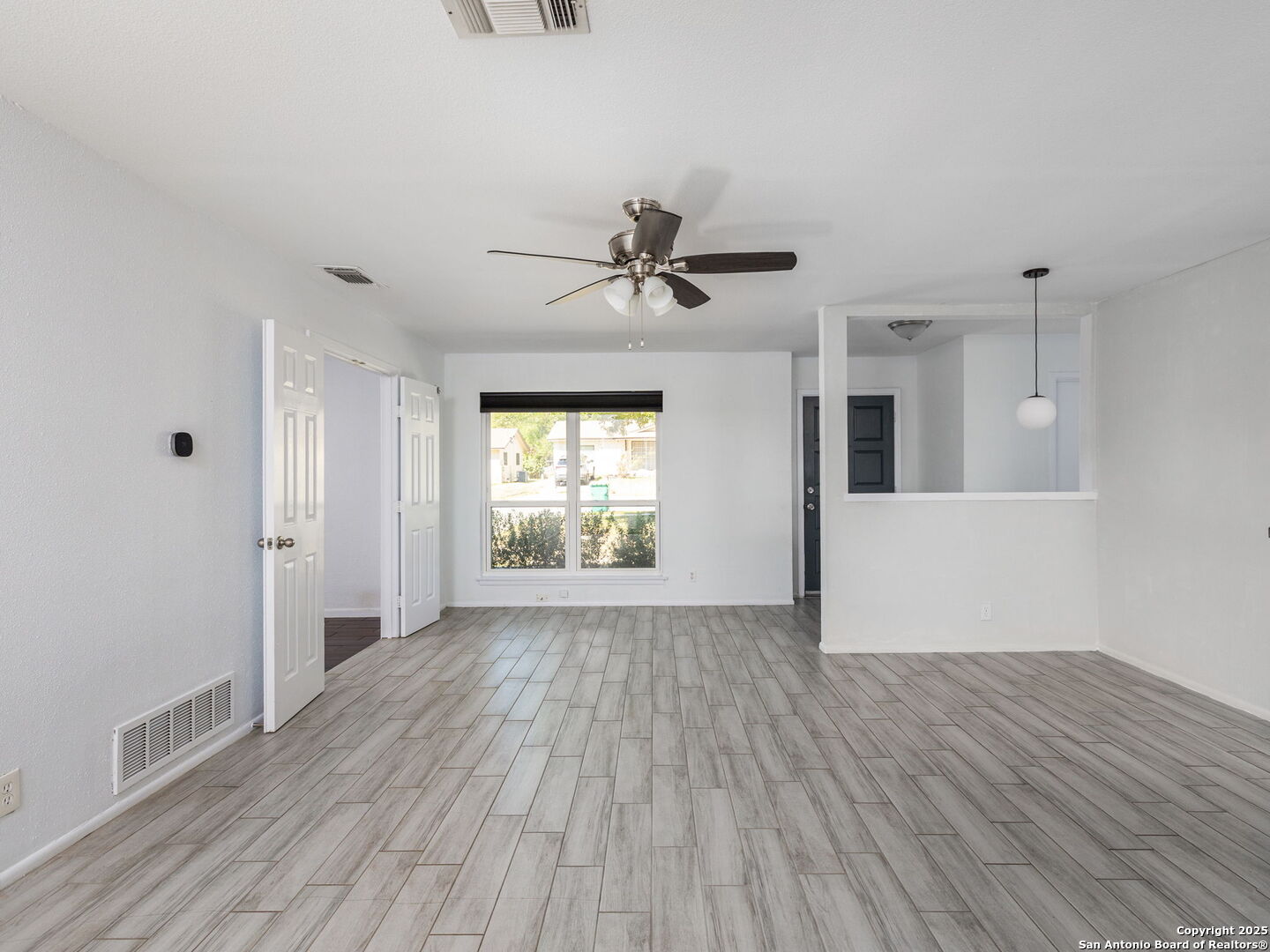 422 Bridgit Drive Converse, TX 78109 - Photo 5 of 17 a view of an empty room with wooden floor and a window