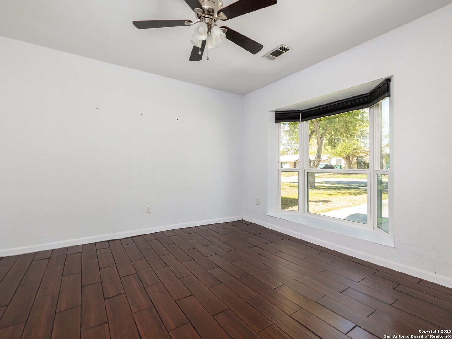 422 Bridgit Drive Converse, TX 78109 - Photo 7 of 17 wooden floor in an empty room with a window