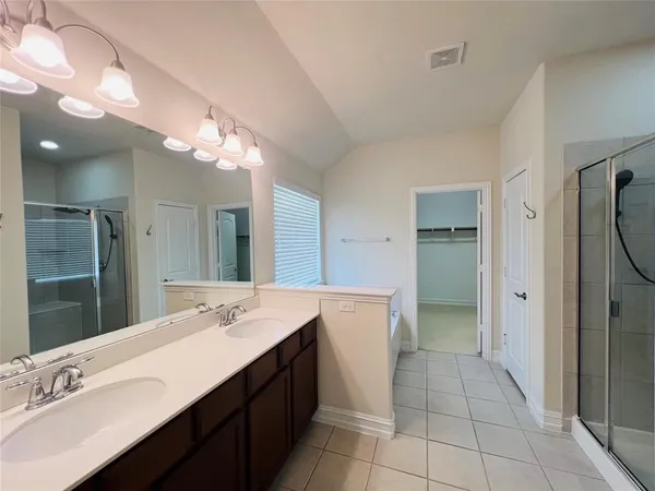 a spacious bathroom with a double vanity sink a mirror and a shower