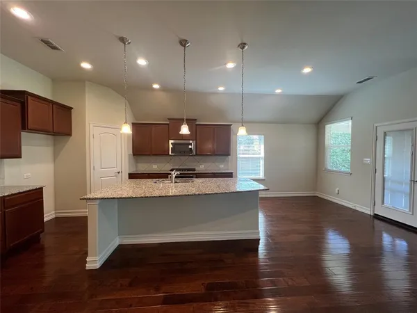 a view of kitchen with sink microwave refrigerator and outdoor view