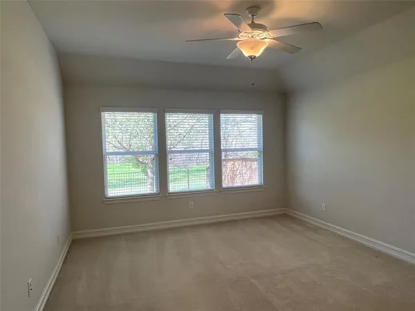 an empty room with a window and a fan